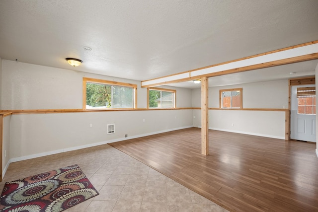 basement with light hardwood / wood-style floors and a textured ceiling