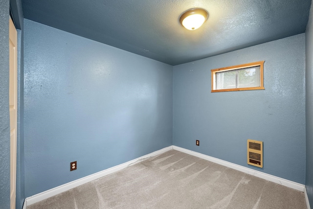 carpeted spare room featuring heating unit