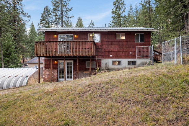 rear view of property featuring a deck and a yard