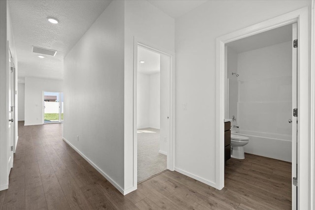 hallway featuring hardwood / wood-style floors and a textured ceiling