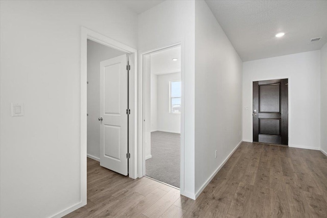 hallway with light hardwood / wood-style floors