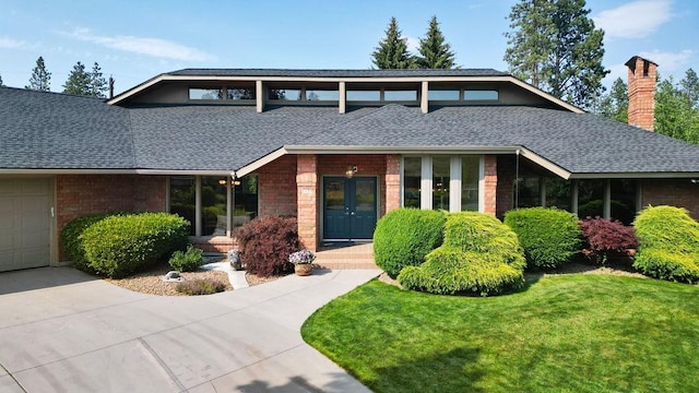 view of front of house featuring a garage, a front yard, and french doors