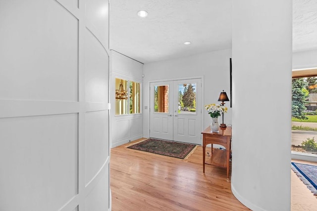 foyer entrance with light hardwood / wood-style flooring and french doors