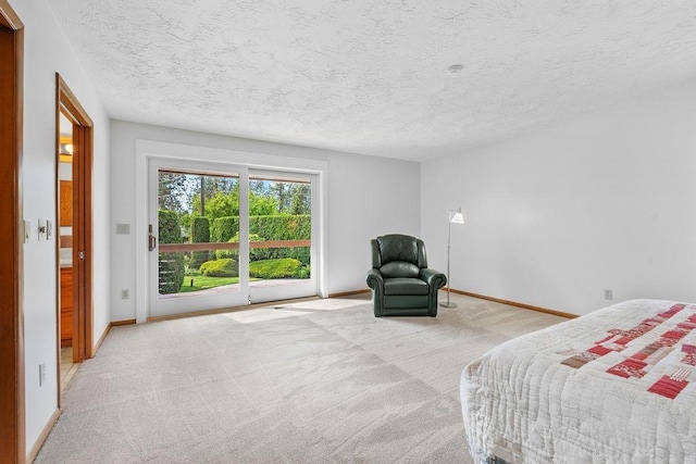 bedroom featuring access to outside, light colored carpet, and a textured ceiling