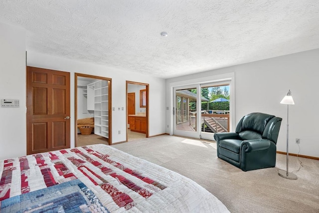 carpeted bedroom with a walk in closet, a textured ceiling, access to outside, and a closet