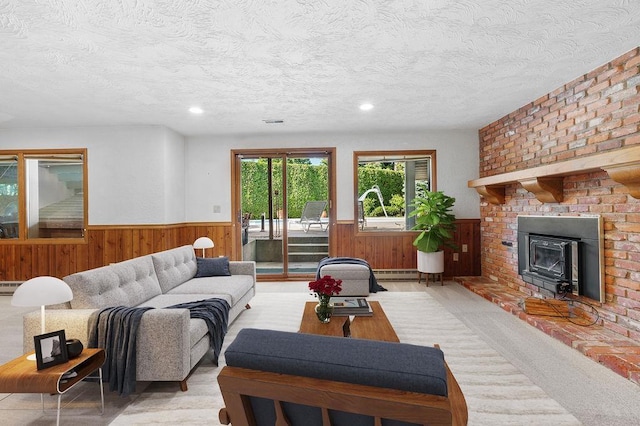 carpeted living room featuring a textured ceiling, a wood stove, and a baseboard heating unit