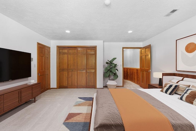 carpeted bedroom with a textured ceiling and a closet