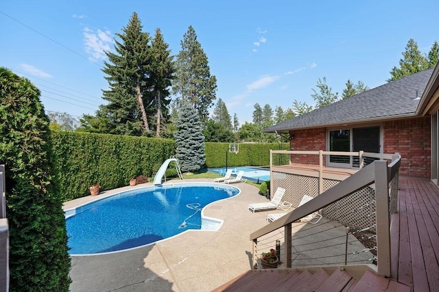 view of pool featuring a wooden deck and a water slide