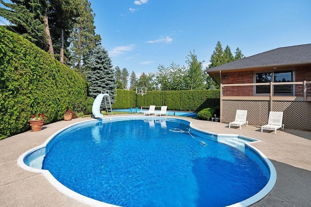 view of swimming pool featuring a patio area and a water slide