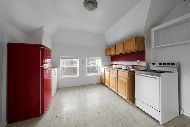 kitchen with black fridge, stove, lofted ceiling, and sink