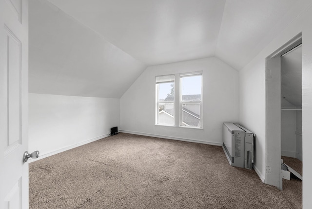 additional living space featuring carpet flooring, heating unit, and lofted ceiling