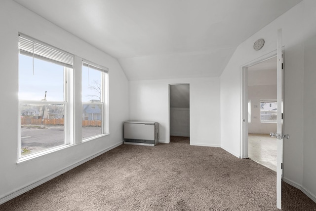 interior space with carpet, heating unit, and vaulted ceiling