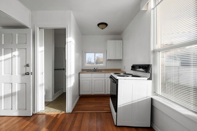 kitchen featuring white cabinetry, white range with electric cooktop, dark wood-type flooring, and sink