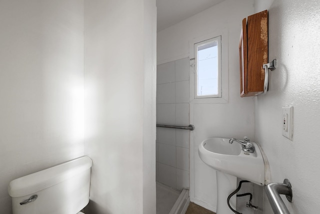 bathroom featuring a shower and toilet