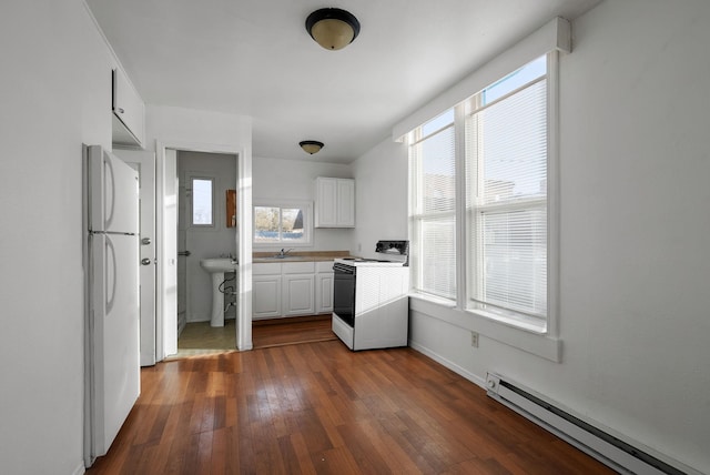 kitchen with plenty of natural light, white cabinetry, white appliances, and a baseboard radiator