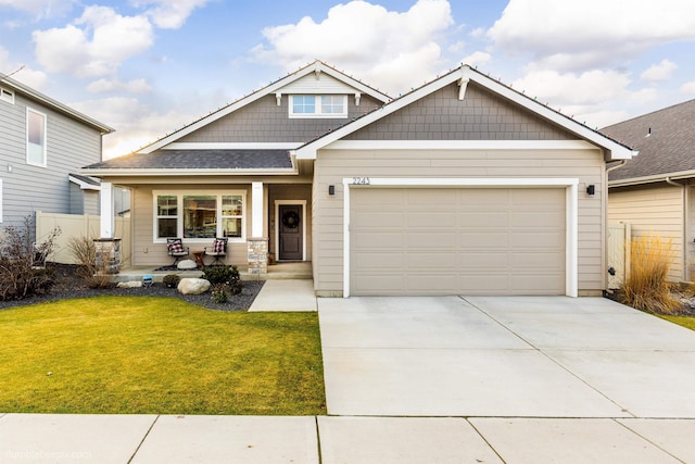 craftsman inspired home with covered porch, a front yard, and a garage