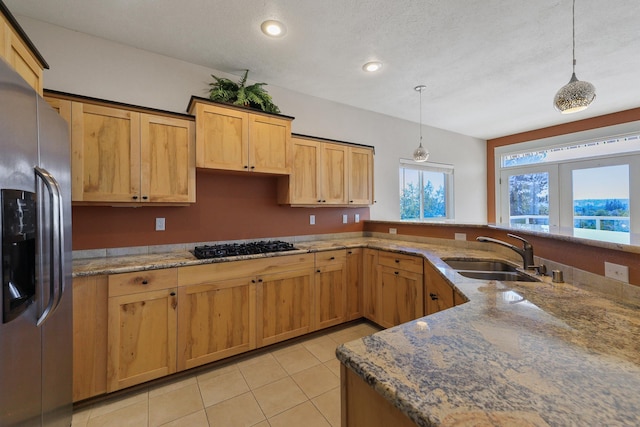 kitchen featuring decorative light fixtures, stainless steel fridge, sink, and gas cooktop