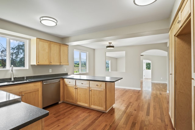 kitchen with kitchen peninsula, dishwasher, hardwood / wood-style floors, and sink