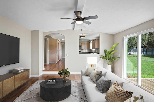 living room featuring dark hardwood / wood-style flooring, vaulted ceiling, and ceiling fan