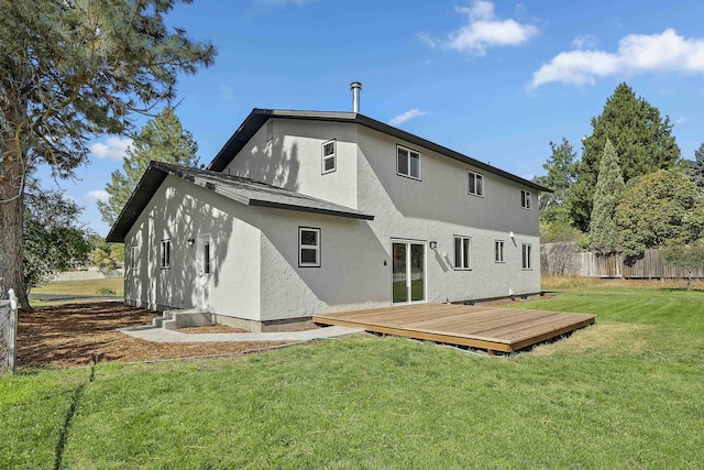 rear view of property featuring a wooden deck and a yard