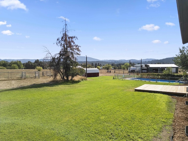 view of yard featuring a deck with mountain view and a rural view