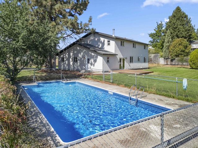 view of swimming pool with a yard