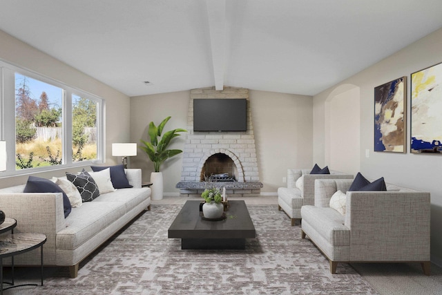 living room featuring vaulted ceiling with beams and a fireplace