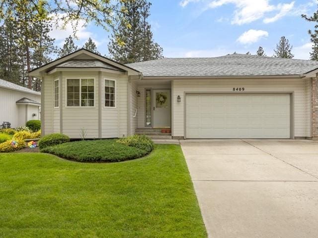 ranch-style house featuring a front yard and a garage