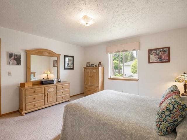 bedroom featuring light carpet and a textured ceiling