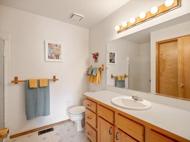 bathroom featuring vanity, toilet, and walk in shower