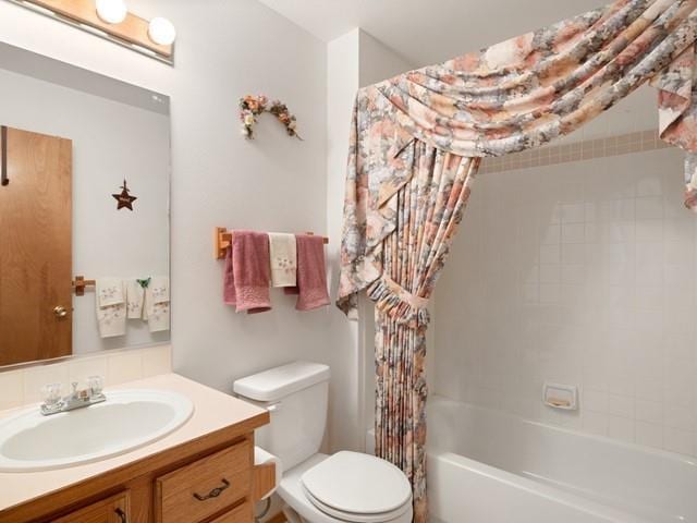 full bathroom featuring vanity, shower / bath combination with curtain, and toilet