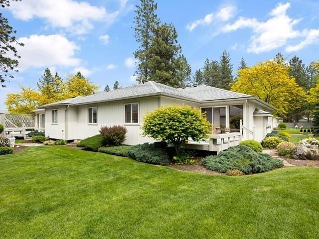 rear view of house featuring a lawn