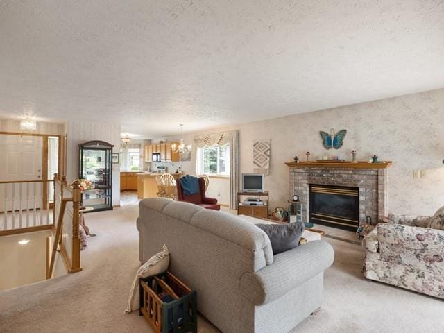 carpeted living room with a fireplace and an inviting chandelier