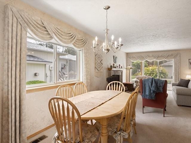 carpeted dining area with a chandelier