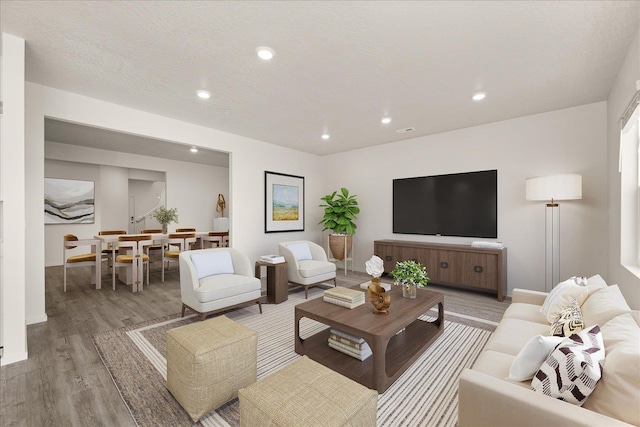 living room with wood-type flooring and a textured ceiling