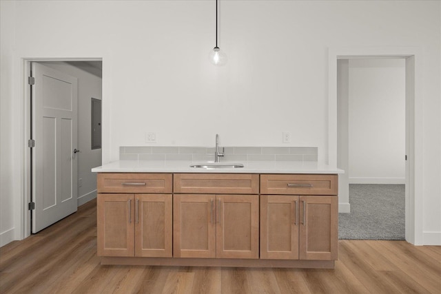 4233 W Tolliver Ct, Spokane, WA 99208 - kitchen featuring light wood-type flooring, light countertops, brown cabinets, hanging light fixtures, and electric panel