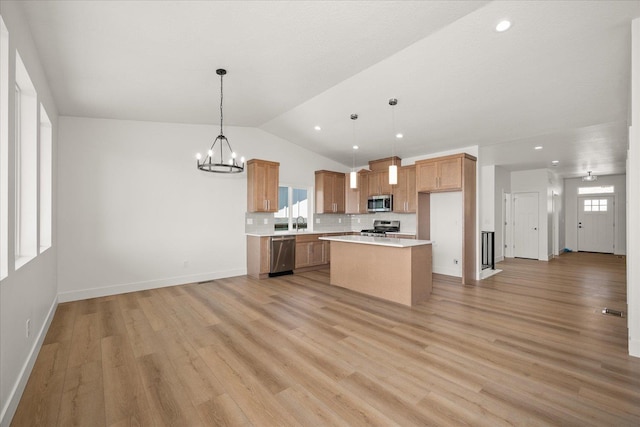 4233 W Tolliver Ct, Spokane, WA 99208 - kitchen with appliances with stainless steel finishes, open floor plan, light countertops, a chandelier, and vaulted ceiling