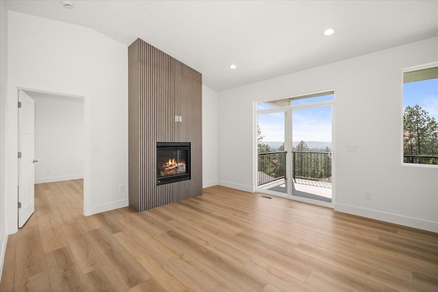 4233 W Tolliver Ct, Spokane, WA 99208 - unfurnished living room featuring light wood-type flooring, a fireplace, vaulted ceiling, and recessed lighting