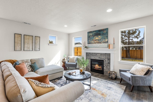 living room featuring a fireplace, hardwood / wood-style floors, and a textured ceiling