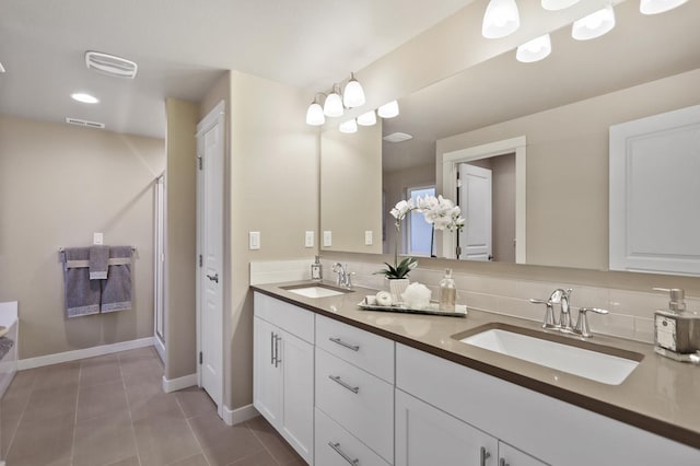 bathroom featuring tile patterned floors, vanity, and a shower with door