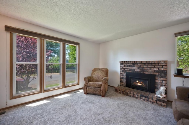 sitting room featuring carpet, a textured ceiling, and a brick fireplace