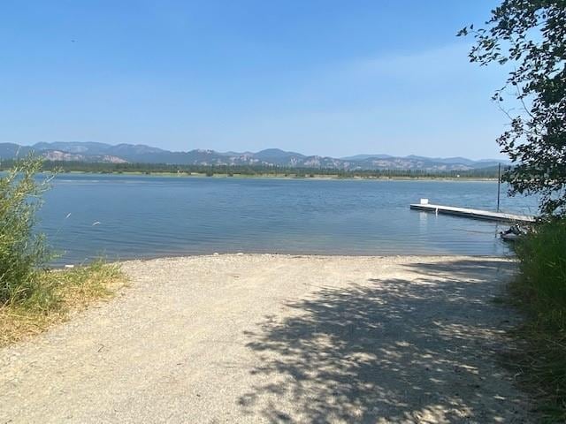 water view with a mountain view and a dock