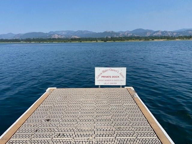 view of dock featuring a water and mountain view and central AC