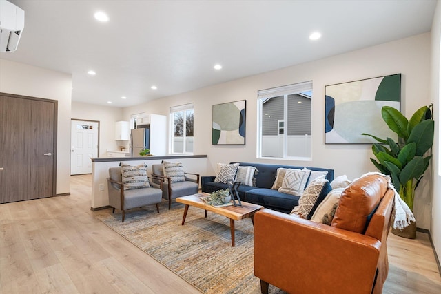 living room featuring a wall unit AC and light hardwood / wood-style flooring