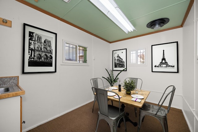 dining area featuring crown molding and dark colored carpet