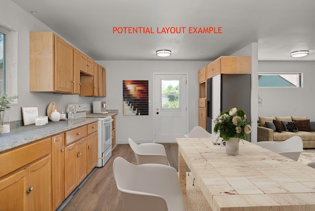 kitchen with wood-type flooring, stainless steel refrigerator, and white range with electric stovetop