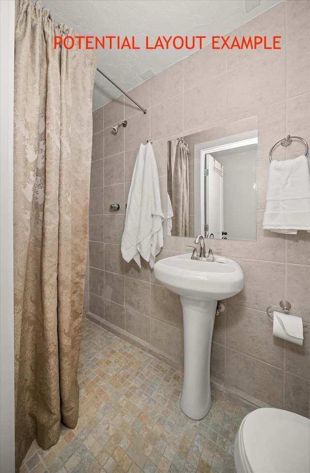 bathroom featuring tile walls and toilet