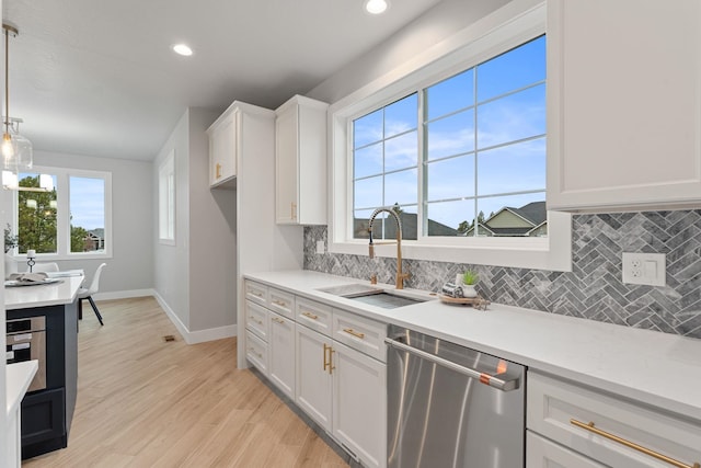 kitchen featuring sink, white cabinetry, a wealth of natural light, pendant lighting, and stainless steel appliances