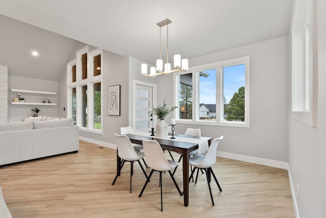 dining room with lofted ceiling, light hardwood / wood-style flooring, built in features, and a notable chandelier