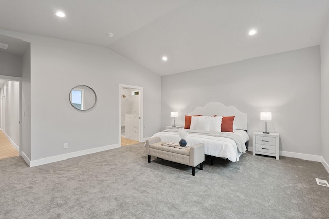 bedroom featuring lofted ceiling, carpet floors, and ensuite bathroom